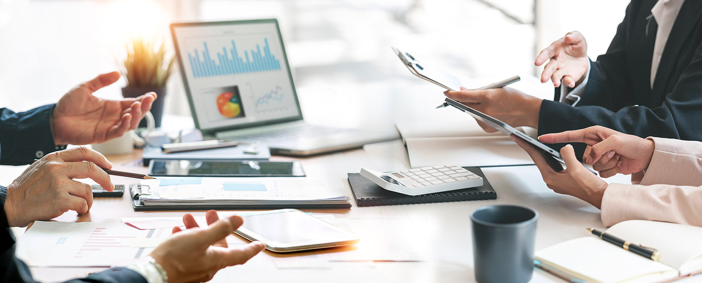 Business meeting with laptop showing financial graphs.